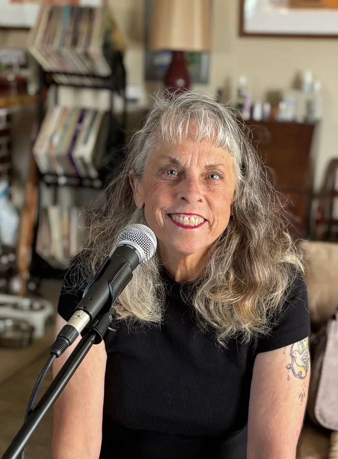 Susan Quaglietti smiling beside a microphone